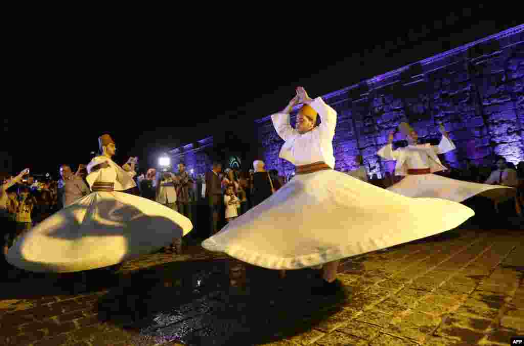 Syrian whirling dervishes perform in a celebration during the Muslim holy month of Ramadan outside the Umayyad Mosque in the old city of the capital, Damascus. (AFP/Louai Beshara)