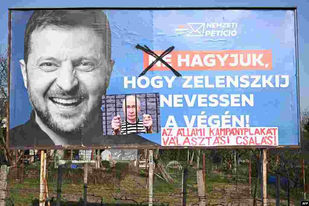 Урядовий білборд із зображенням президента України Володимира Зеленського та слоганом «Не дамо Зеленському сміятися останнім», у місті Печ, Угорщина, 13 березня 2026 року. Слово «не» закреслили, а до зображення додали фото президента Росії Володимира Путіна з надписом «урядовий передвиборчий білборд – це виборче шахрайство». Кампанія триває в умовах напруженої політичної боротьби, де ключовою темою стали відносини з Україною