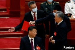 Fostul președinte chinez Hu Jintao este escortat de la ceremonia de închidere a Congresului Partidului Comunist, organizat sâmbătă în Marea Sală a Poporului din Beijing, China, 22 octombrie 2022. Acesta stătea în stânga lui Xi Jinping.