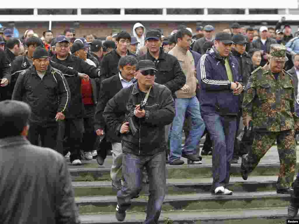 Телохранители помогают Бакиеву покинуть митинг своих сторонников после нападения сторонников временного правительства, Ош, 15 апреля 2010
