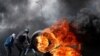 A Palestinian protester moves a burning tire during clashes with Israeli troops near the Jewish settlement of Beit El in the Israeli-occupied West Bank on March 27. (Reuters/Mohamad Torokman)