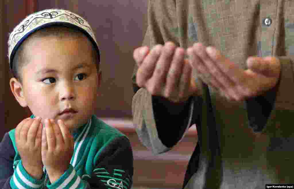 A Kyrgyz Muslim boy prays during the Eid al-Fitr celebration in Cholpon-Ata, around 250km from Bishkek.