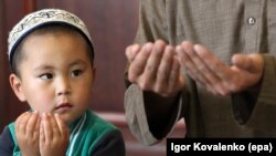 Кыргызстандын Чолпон-Ата шаарындагы жаш бала Айт намаз учурунда бата тилеп олтурат. 25-июнь, 2017-жыл.