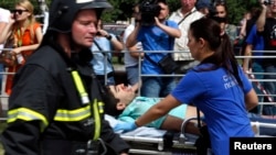 Медики везут пострадавших при аварии в московском метро. 15 июля 2014 года.