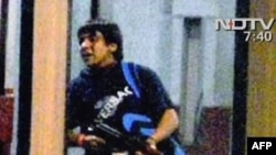 One of the Mumbai attackers carrying an automatic rifle as he enters a train station in Mumbai on November 26.