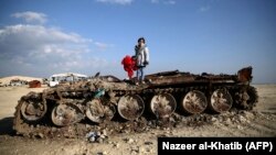 11-летняя сирийская девочка с плюшевым медведем на разбитом танке. 6 километров от границы с Турцией на севере Алеппо. 20 февраля 2019 года.