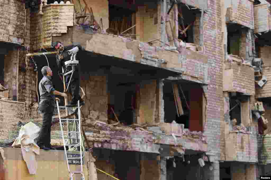 Lebanese security officers adjust surveillance cameras at the entrance of the Iranian embassy in Beirut on November 19. Two suicide bombings rocked the embassy compound, killing at least 23 people, including an Iranian cultural attache. (Reuters/Hasan Shaaban)