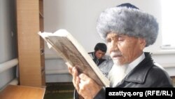 Местный житель читает Коран в мечети имени духовного наставника Досжана. Поселок Шубаркудык. 16 ноября 2013 года. 