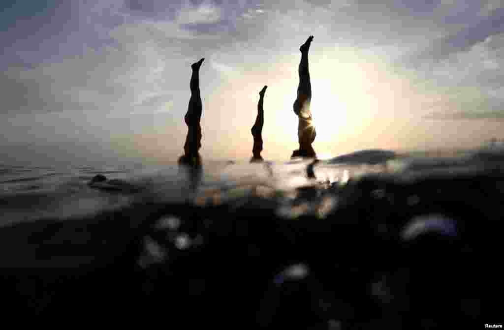 People practice stand-up paddleboard yoga, or SUP yoga, on the Adriatic coast in Verudela, Croatia. (Reuters/Antonio Bronic)