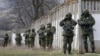Вооруженные люди в военной форме без опознавательных знаков, заблокировавшие украинскую воинскую часть к Крыму в селе Перевальное недалеко от Симферополя. 19 марта 2014 года.