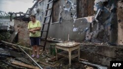 Жінка біля зруйнованого будинку на Луганщині, серпень 2015 року 