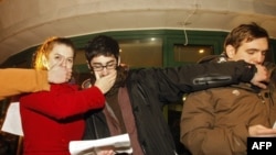 Hungarian students cover each other's mouths with their hands as they take part in a demonstration against the new media law in Budapest on December 20.