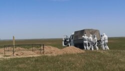 Люди в защитных костюмах на кладбище за чертой Алматы, отведеденном для захоронения умерших от коронавируса.