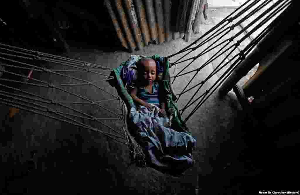 An infant sleeps in a hammock at a makeshift shelter in Kolkata on April 23. (Reuters/Rupak De Chowdhuri)