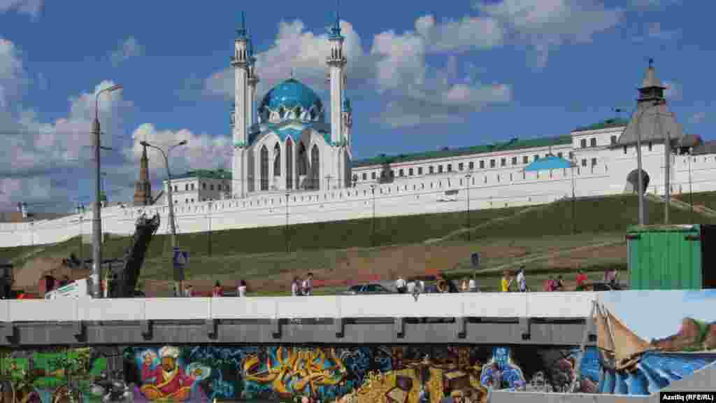 A mural lines the edges of a reservoir near a central mosque.