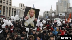 Demonstrators gathered holding placards and balloons during a December 24 protest in Moscow against the Duma elections earlier that month.