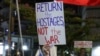 A demonstrator holds a sign during a protest calling for action to release the remaining hostages held captive in Gaza since the 2023 October 7 attacks by Palestinian militants, outside the Israeli Defence Ministry headquarters in Tel Aviv on March 1, 202