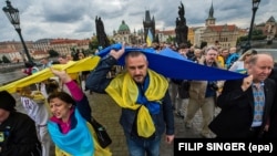 Члени української громади в Чехії несуть гігантський український прапор під час маршу до дня Дня Незалежності України на середньому Карловому мосту в Празі. Чехвія, 24 серпня 2014 року