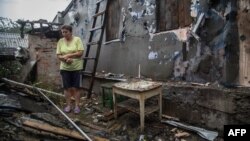 Жінка біля свого зруйнованого обстрілами будинку в Золотому, за 60 кілометрів на захід від Луганська, 16 серпня 2015 року