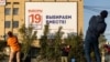 Адамдар парламент сайлауының баннері алдында жаттығу жасап жатыр. Якутск, Ресей. 7 қыркүйек 2021 жыл.