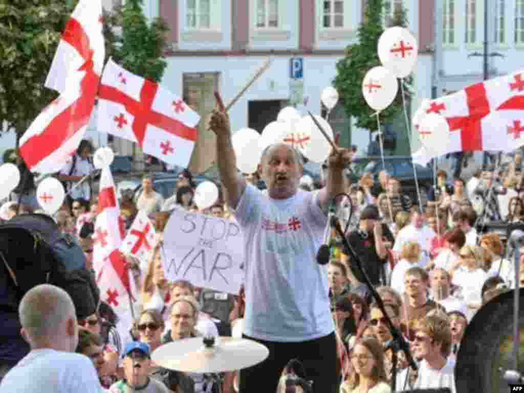 Литва, 14 серпня 2008 р. - A participant (C) composes the Be2gether festival's record-breaking drum fiesta near the Vilnius city hall, on August 14, 2008 to support Georgia. Musicians, artists, actors and the several hundred drummers who gather together used percussion instruments to make a musical statement, Georgia2gether, and to express their position on the war which has begun in Georgia. AFP PHOTO/PETRAS MALUKAS