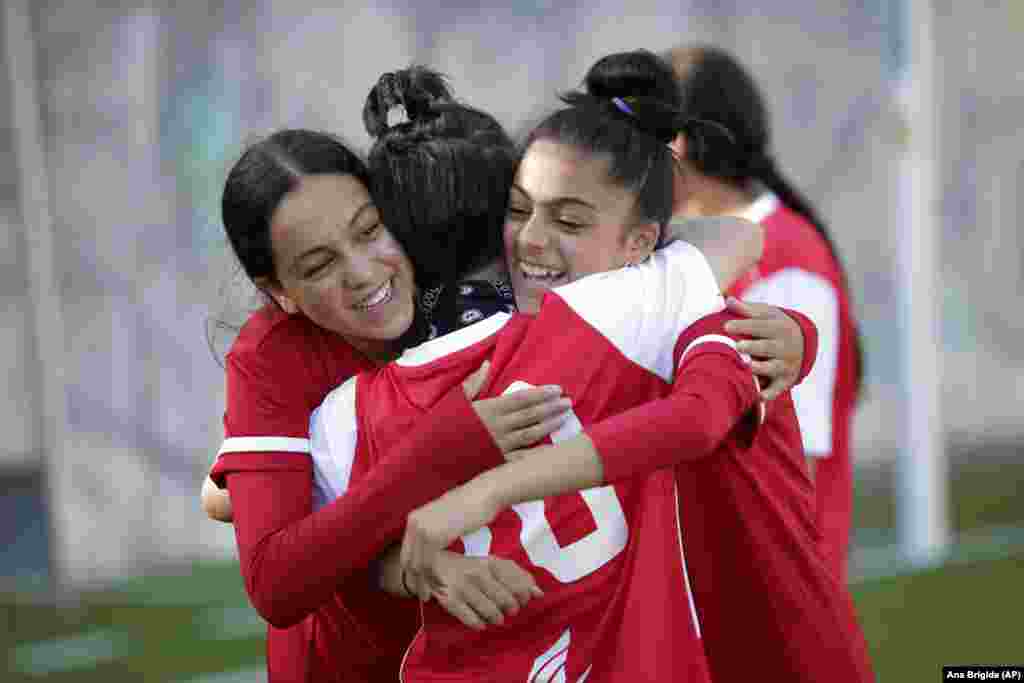 Team members hug during a training session at a soccer pitch in Odivelas, outside Lisbon, Thursday, Sept. 30, 2021