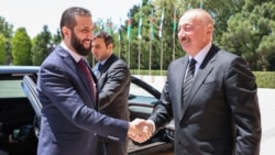 This handout picture released by the Syrian Presidency shows Azerbaijan's President Ilham Aliyev (right) receiving Syria's interim President Ahmed al-Sharaa in Baku on July 12.