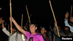 Supporters of Muhammad Tahirul Qadri, Sufi cleric and leader of political party Pakistan Awami Tehreek (PAT), chant slogans as they wave sticks during a protest in Lahore August 8, 2014. 