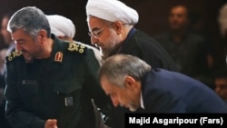 Iranian president Hassan Rouhani (C) alongside IRGC's top commander Mohammad Ali Jafari (L) and his brother Hossein Fereydoun in a ceremony in Tehran On September 16, 2013.