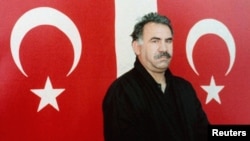 Kurdish rebel leader Abdullah Ocalan poses in front of Turkish flags after he arrived at the prison island of Imrali, in the Sea of Marmara, in February 1999.