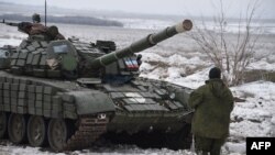 A pro-Russian separatist stands in front of a tank at a checkpoint in Yenakieve, 25 kilometers from the eastern town of Debaltseve, on January 29.