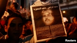 Демонстрант несет постер с портретом убитого тунисского оппозиционного политика Мохаммеда Брахми. 25 июля 2013 года.
