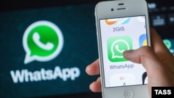 Смартфон на фоне иконки мессенджера WhatsApp. 