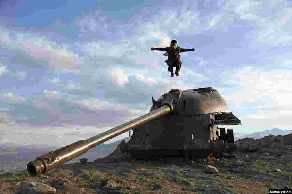 An Afghan boy jumps off the turret of a Soviet tank on a hilltop on the the outskirts of Kabul. (AP/Rahmat Gul)