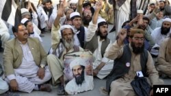 Supporters of the hard-line pro-Taliban Pakistani party Jamiat Ulema-e Islam (JUI) carry a portrait of slain Al-Qaeda leader Osama bin Laden at a rally in Quetta on May 2, 2013.