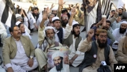 FILE: Pakistani supporters of hard-line pro-Taliban party Jamiat Ulema-e-Islam (JUI) carry a portrait of the slain Al-Qaeda leader Osama bin Laden during a protest in 2013.