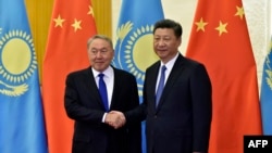 Kazakh President Nursultan Nazarbayev (L) and Chinese President Xi Jinping shake hands before their meeting at the Great Hall of the People, on the sidelines of the Belt and Road forum in Beijing on May 14.
