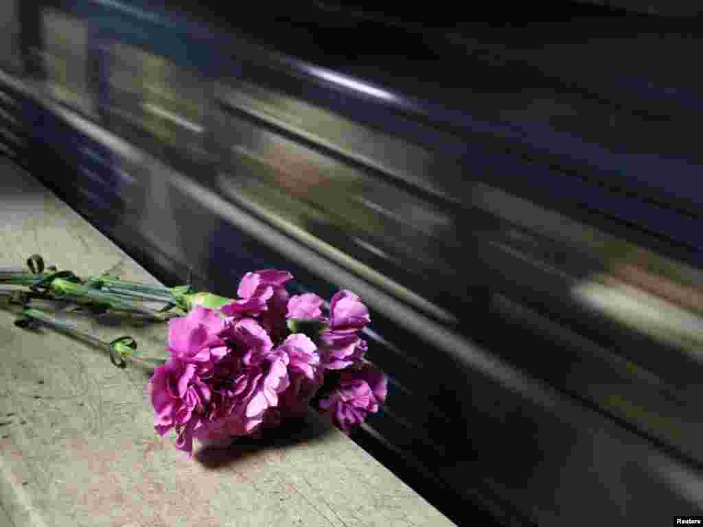 A train passes by flowers left in memory of the victims of the bombing at Park Kultury subway station in Moscow. - Photo by Denis Sinyakov for Reuters