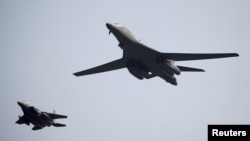 A U.S. Air Force B-1B bomber (right) flies over Osan Air Base in Pyeongtaek, South Korea.