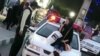 Photo published on social media shows a young woman sitting on a police car in Iran. Undated. Later a doctor jumped on a police car as protest hijab warning.