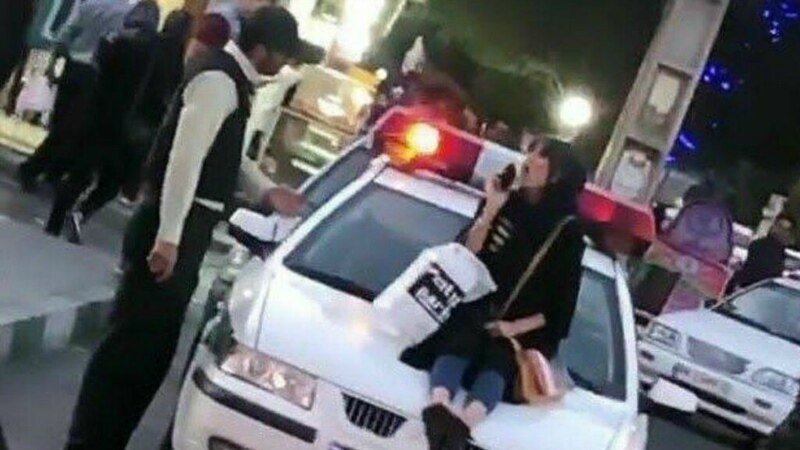 بازداشت زن جوانی که به اعتراض روی خودروی پلیس نشست