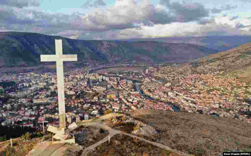 A viewpoint above Mostar dominated by a 33-meter high cross. Since the end of the conflict in 1994, Mostar has been divided with Croats mostly living on the west side of the Neretva River (left side of photo) and Bosniaks to the east. 