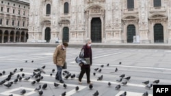 Egy idős pár sétál a milánói dóm előtti üres téren, 2020. március 31-én. (Képünk illusztráció)