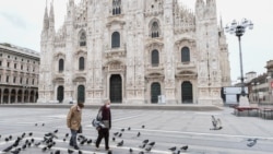 Пожилая пара на опустевшей площади Дуомо в Милане.