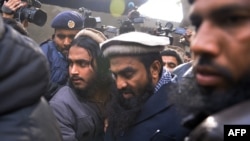 Pakistani security personnel escort Zakiur Rehman Lakhvi (center), the alleged mastermind of the 2008 Mumbai attacks, as he leaves a court in Islamabad in 2014.