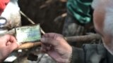 Forenzičari pregledaju dokumente pronađene uz ljudske kosti u masovnoj grobnici u selu Ivan Polje blizini Rogatice, maj 2011