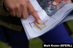 Археолог Ян Гасил показывает схематическое изображение бараков трудового лагеря