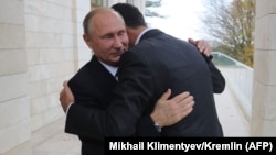 Russian President Vladimir Putin (left) and his Syrian counterpart, Bashar al-Assad, embrace in Sochi on November 20.