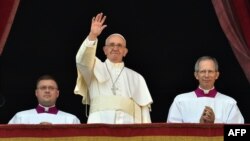 Pope Francis waves from the balcony of St Peter's Basilica during the traditional "Urbi et Orbi" Christmas message to the city and the world, on St Peter's Square in the Vatican on December 25.