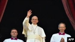 Pope Francis waves from the balcony of St Peter's basilica during the traditional "Urbi et Orbi" Christmas message in 2015.